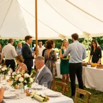 Marquee hire London setup for a wedding reception with guests enjoying a vibrant outdoor event.